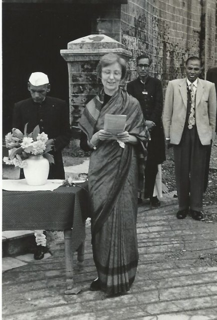 Barbara Beach Alter standing in a sari, reading from papers